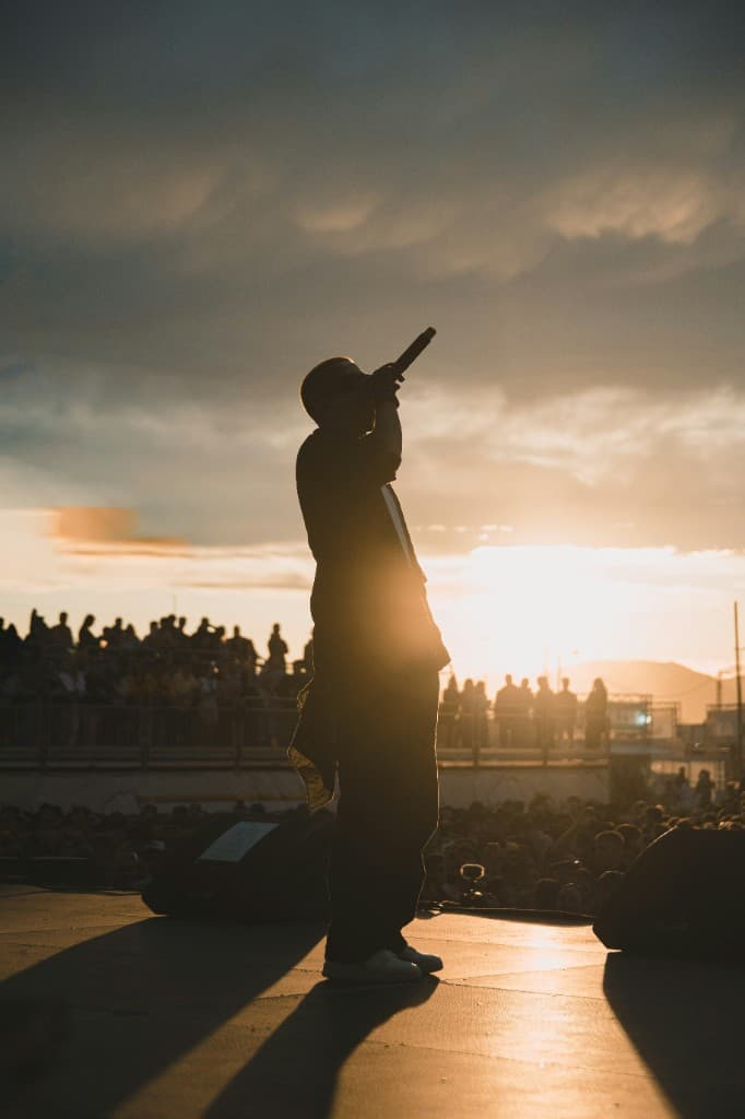 Performer silhouette on stage at sunset concert